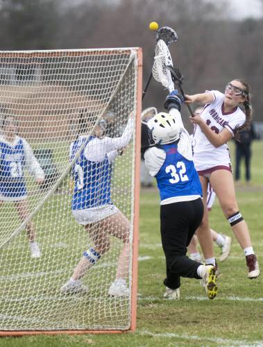 Amherst Regional's Tsukiko Bhowmik, right, attempts a shot, eventually scoring during the lacrosse game against Granby at Granby High School, Friday, April 11, 2025, in Granby.