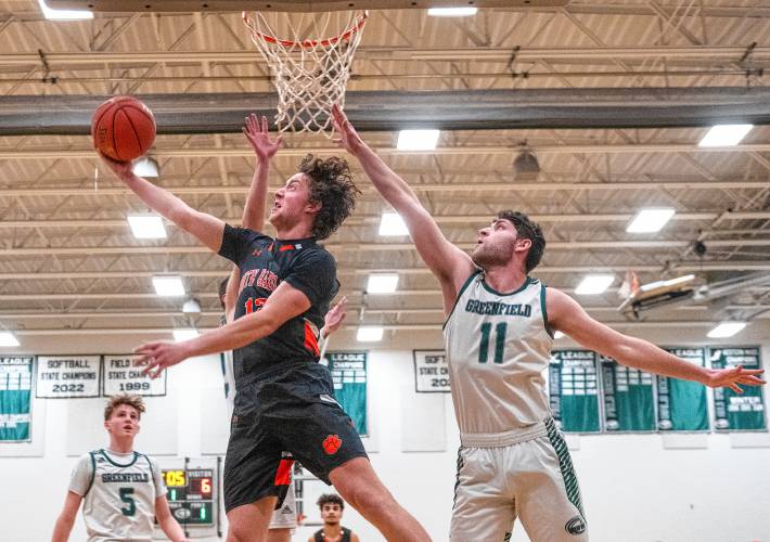 South Hadley’s Jack Loughrey, left, attempts a layup past Greenfield’s Jon Breor (11) on Wednesday in Greenfield.