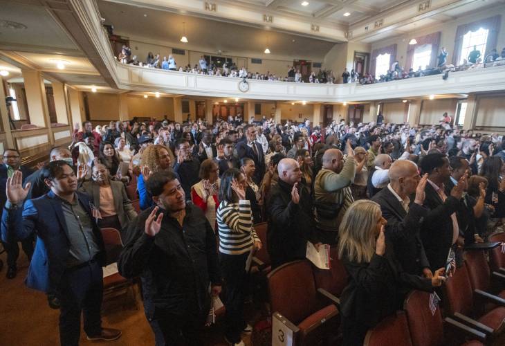 New American citizens recite the Oath of Allegiance during a naturalization ceremony at Bowker Auditorium, Tuesday, in Amherst.
