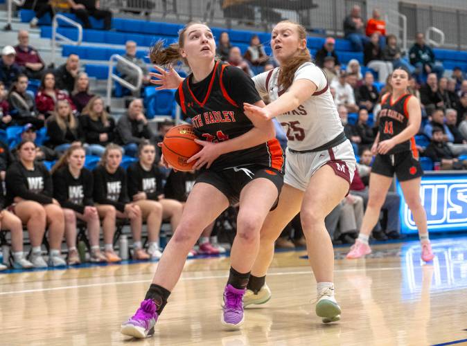 South Hadley's Kate Phillips, left, attempts to dribble past Millis guard Ella Maher, right, during the MIAA Division 4 state semifinal basketball game at Worcester State University, Wednesday, March 12, 2025, in Worcester.
