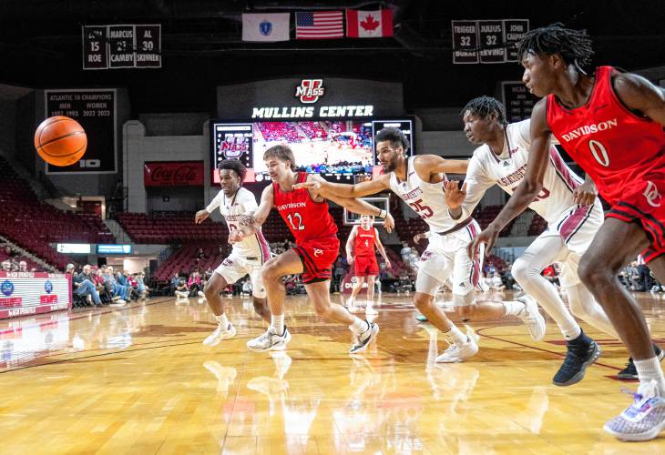 UMass and Davidson players rush toward the ball at the Mullins Center on Wednesday in Amherst.