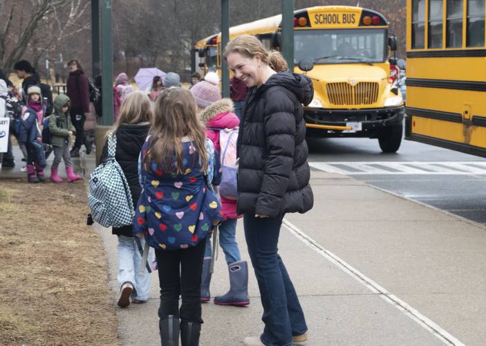 Amy Guillemette, school psychologist at Crocker Farm Elementary School, greets   students as they get off the bus last Wednesday morning., 