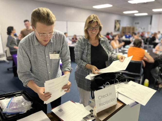From right, Krista Harper, principal investigator of the Holyoke Community Energy Project, and Nick Caverly, anthropology professor, organize papers at a check in for one of the project’s many community workshops.