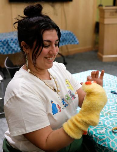 Samantha Morin works on a puppet creation during a deluxe sock puppet class by Homeslice Puppetry on Thursday night at the South Hadley Public Library. 