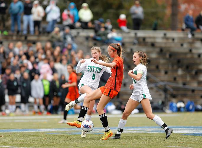 South Hadley’s Maddie Soderbaum (16) fights for possession between Sutton defenders Courtney Clemens (6) and Anna Joseph (22) in the second half of the MIAA Division 4 girls soccer championship Saturday at Doyle Field in Leominster.
