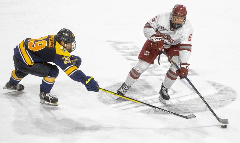 UMass defenseman Lucas Olvestad (6) passes the puck past Merrimack forward Caelan Fitzpatrick (29) during the college hockey game at the Mullins Center, Friday, Jan. 31, 2025, in Amherst.